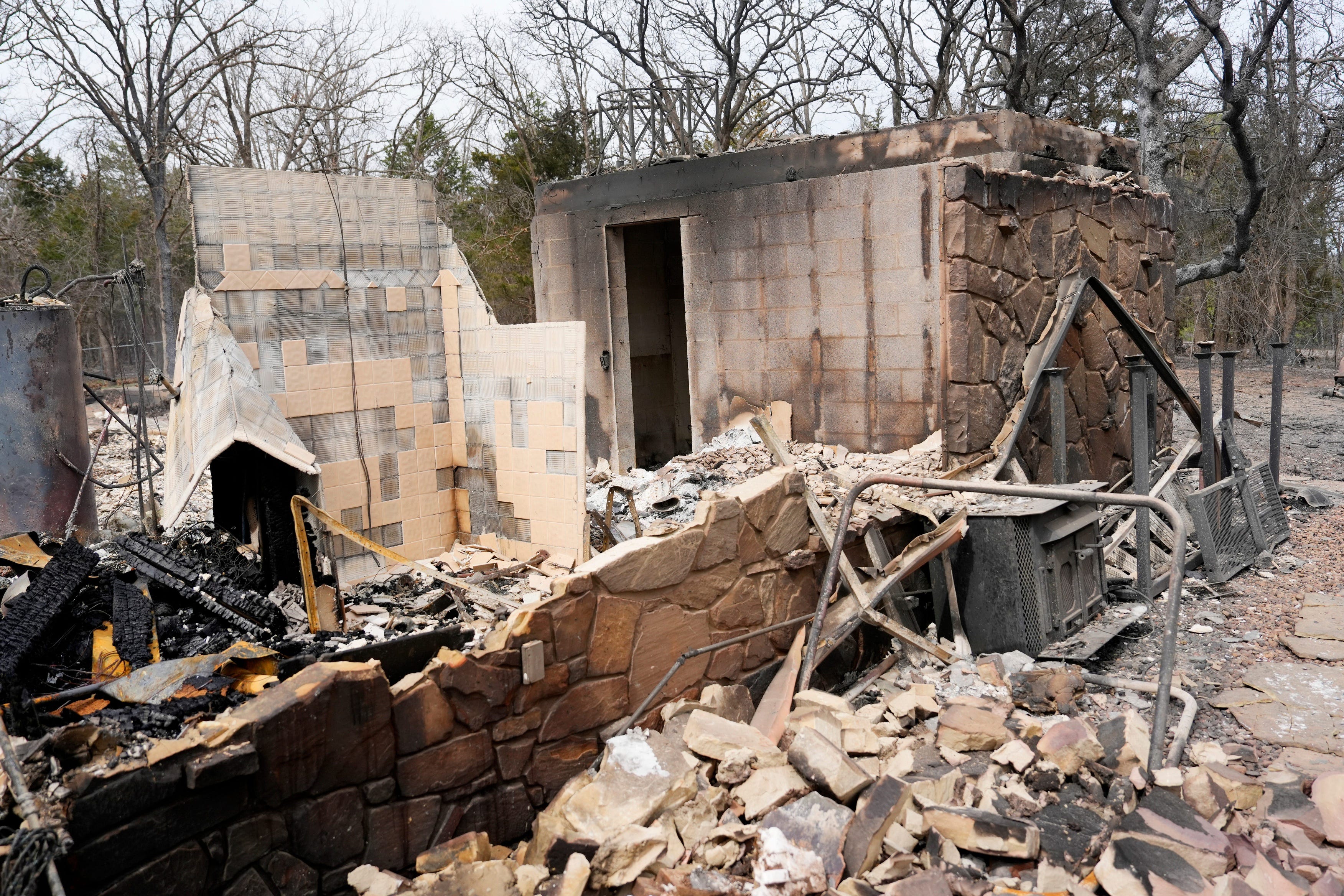 What was once a tornado safe room is about all that was left of a house in the aftermath of wildfires the day before in Stillwater, Saturday, March 15, 2025.