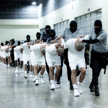 Salvadoran police officers escort alleged members of the Venezuelan gang Tren de Aragua recently deported by the U.S. government to be imprisoned in the Terrorism Confinement Center (CECOT) prison, as part of an agreement with the Salvadoran government, in Tecoluca, El Salvador, in this handout image obtained March 16, 2025.