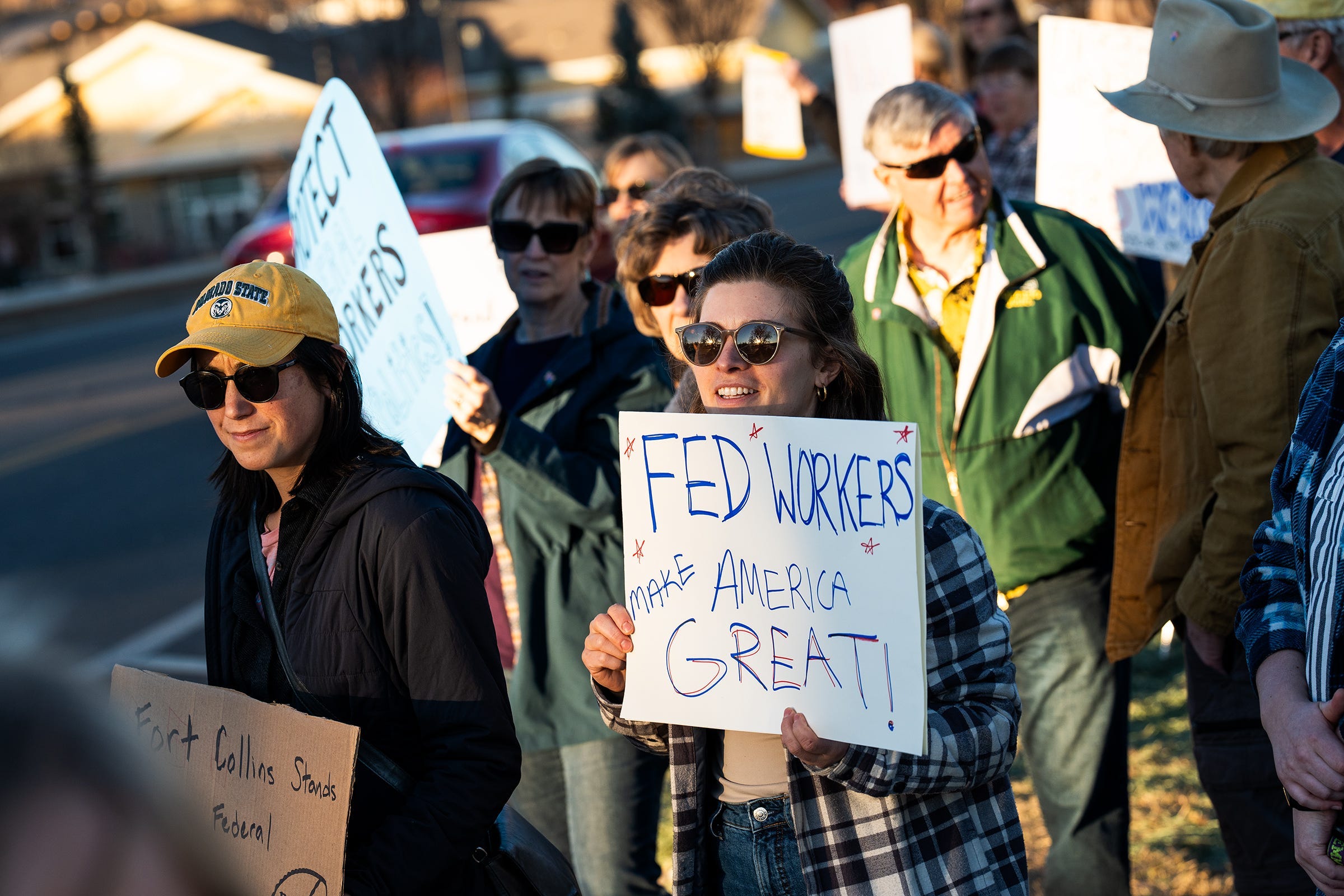Protesters gather on sidewalks in front of federal buildings during a protest in support of federal workers who were recently laid off on Thursday, Feb. 27, 2025 in Fort Collins, Colo.