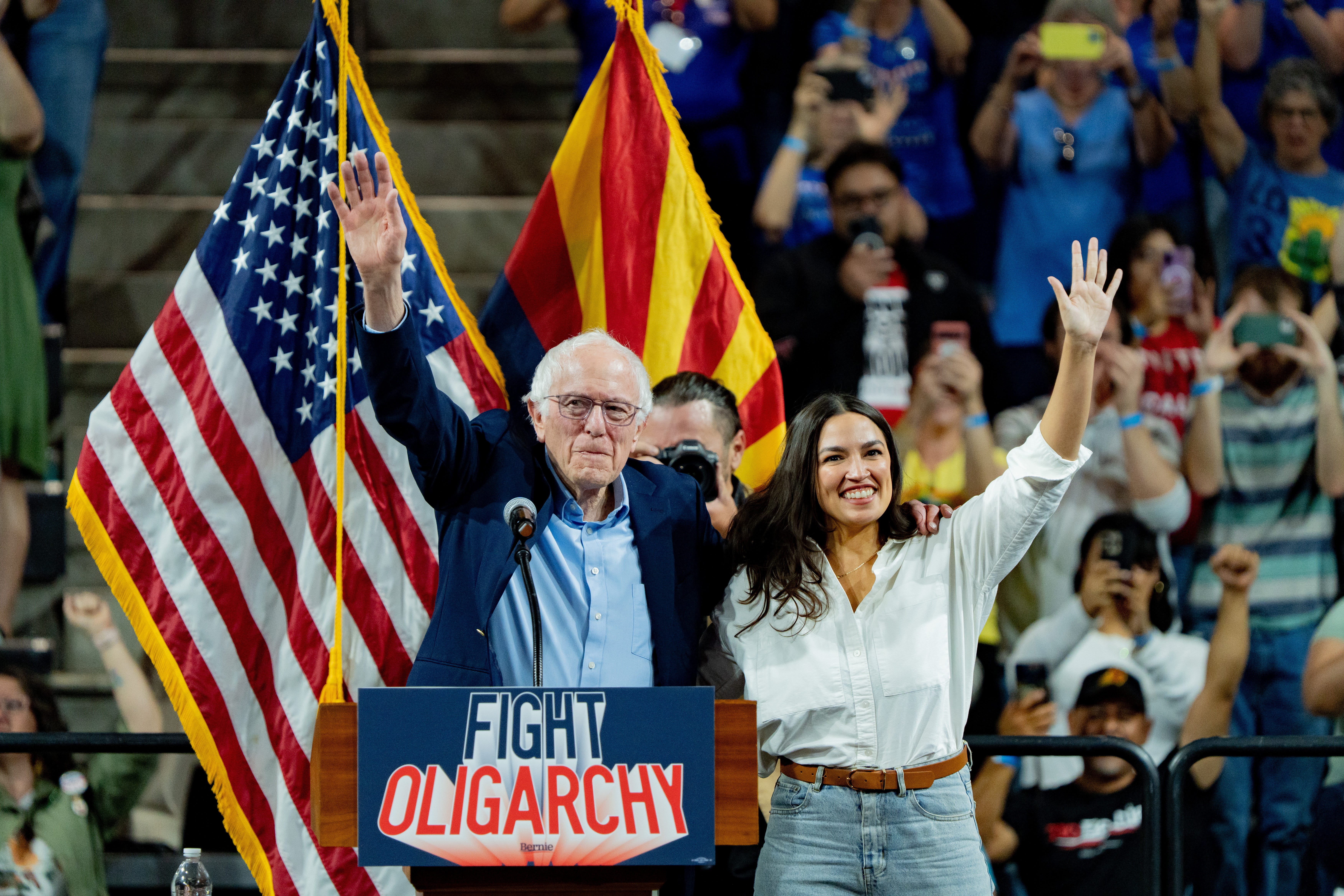 Sen. Bernie Sanders, I-Vt., and Rep. Alexandria Ocasio-Cortez, D-N.Y., wave to supporters during their "Fight Oligarchy" rally in Tempe, Ariz., on March 20, 2025.