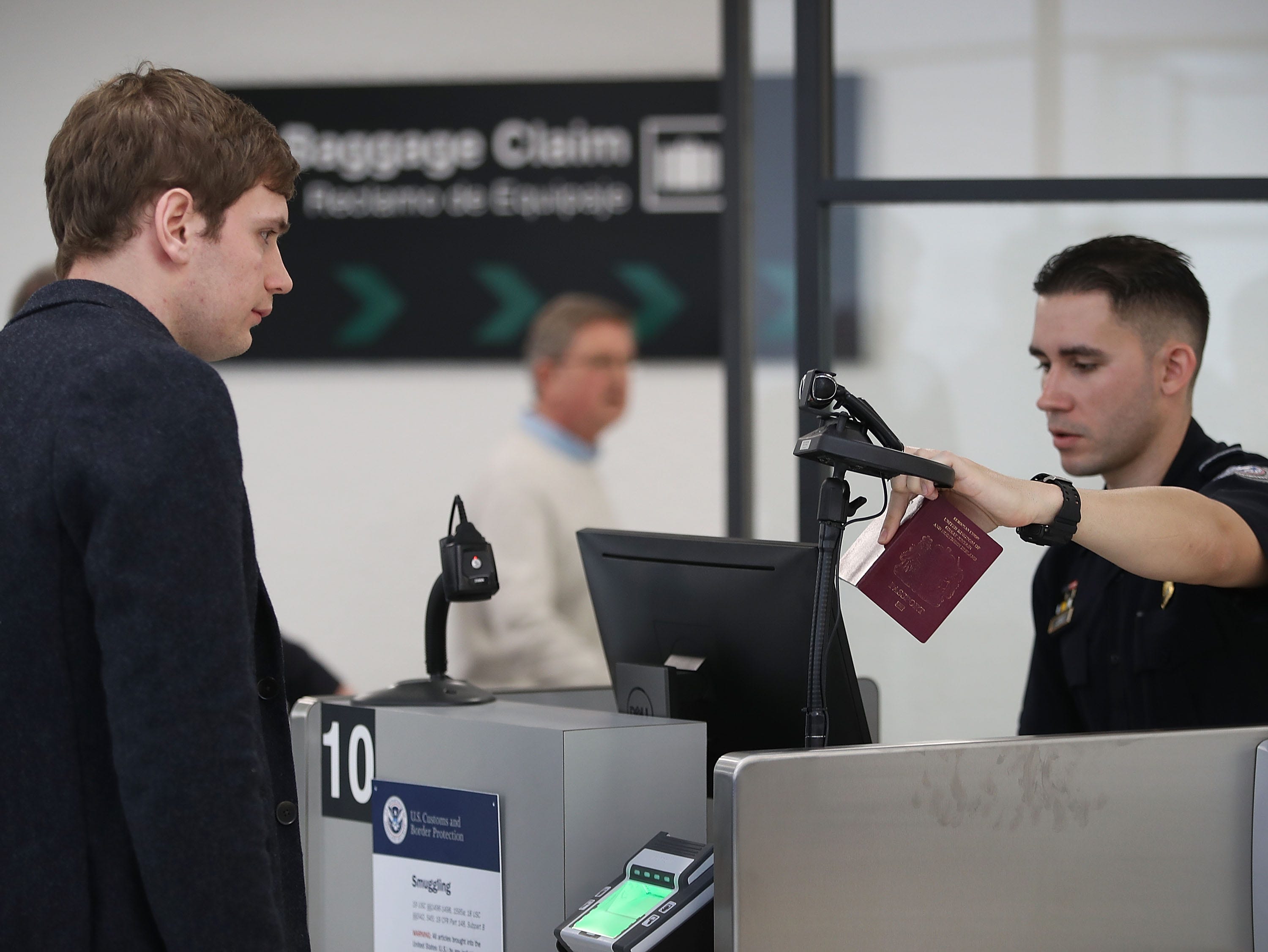 A U.S. Customs and Border Protection officer instructs an international traveler to look into a camera as he uses facial recognition technology to screen a traveler entering the United States on February 27, 2018 at Miami International Airport in Miami, Florida.