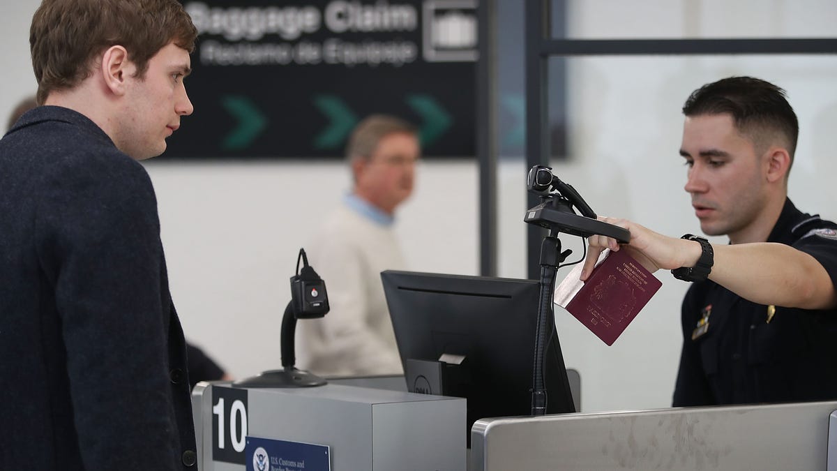 A U.S. Customs and Border Protection officer instructs an international traveler to look into a camera as he uses facial recognition technology to screen a traveler entering the United States on February 27, 2018 at Miami International Airport in Miami, Florida.