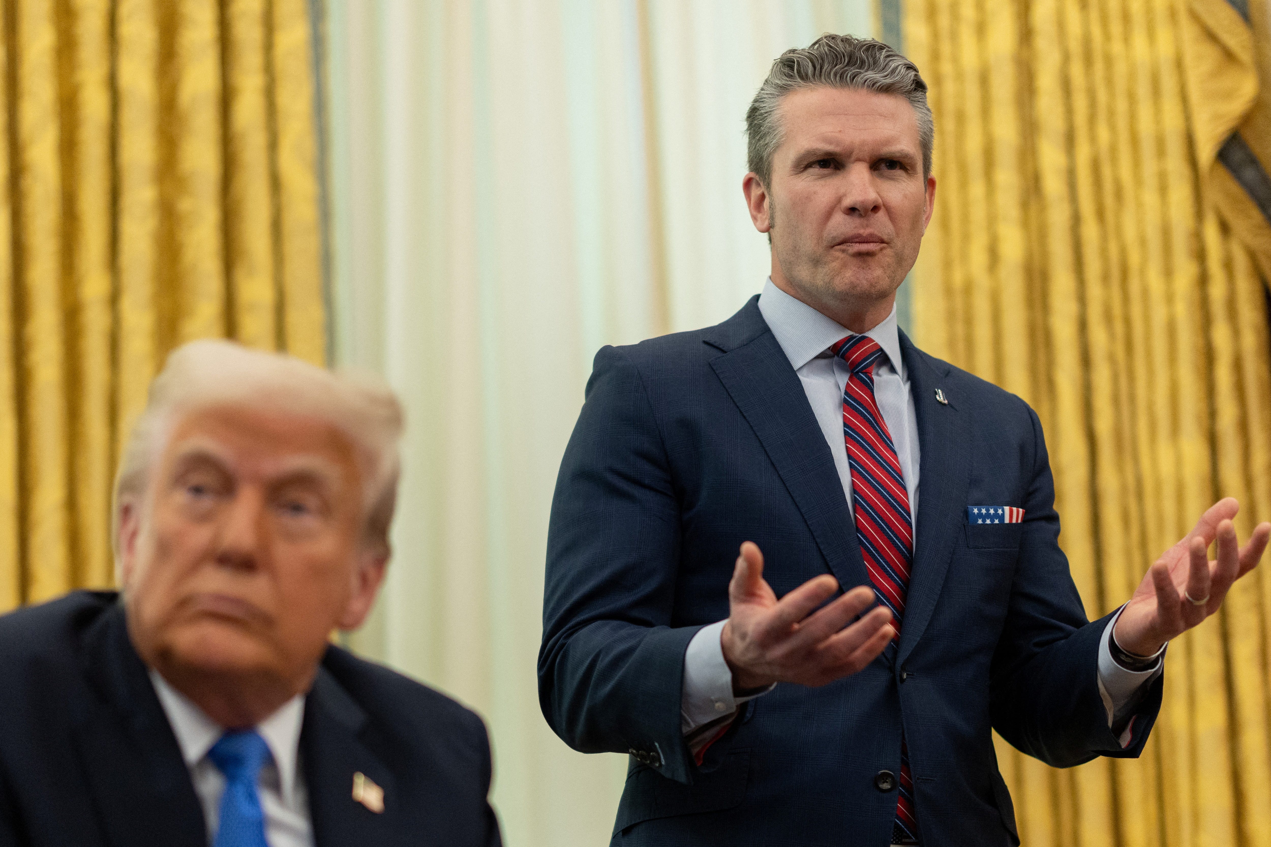 Defense Secretary Pete Hegseth speaks next to President Donald Trump in the Oval Office at the White House on March 21, 2025.