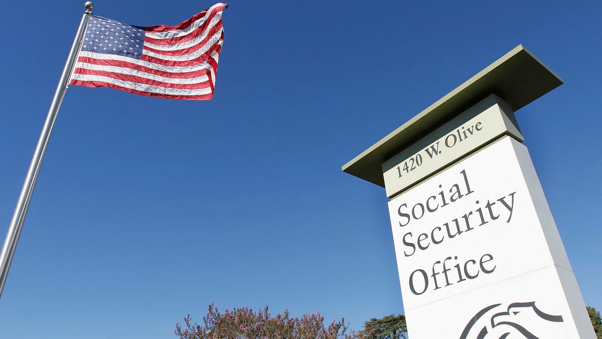 An American flag flutters in the wind next to signage for a Social Security Administration office in Burbank, California on October 25, 2012.