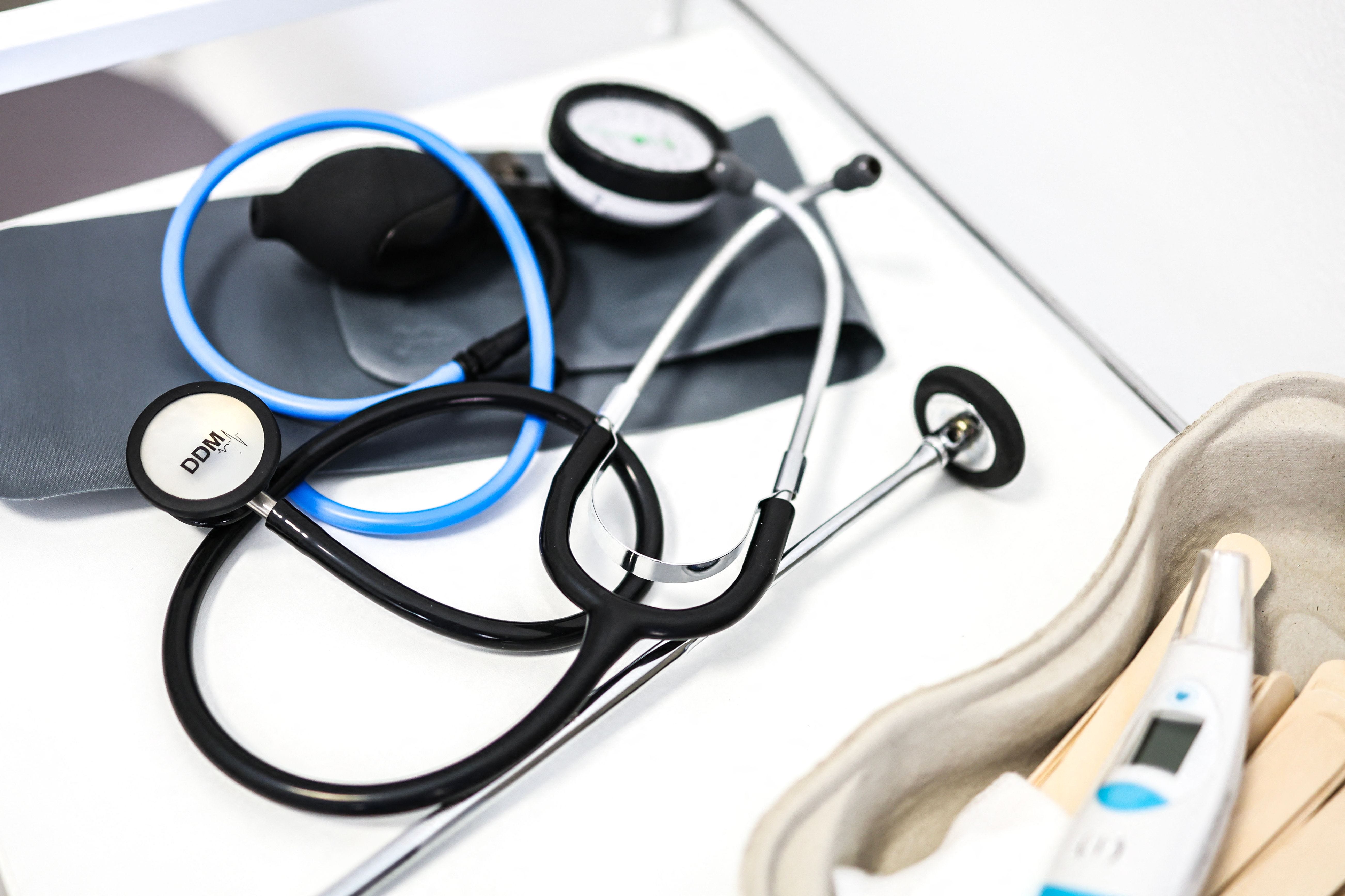 This illustration shows medical instruments including a stethoscope and thermometer as they lie on a table in a doctor's office in Albi, south-western France on June 15, 2023.
