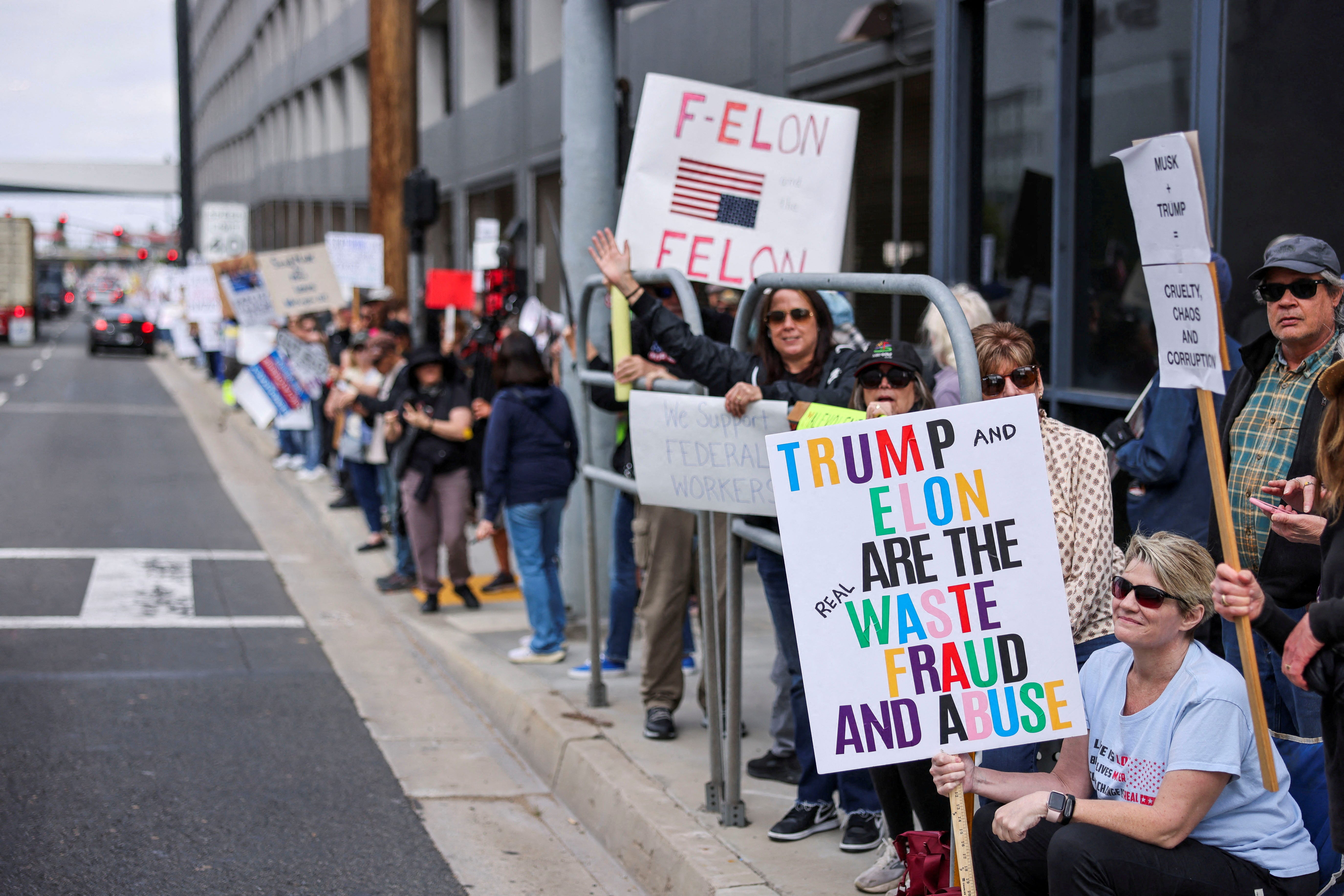 FILE PHOTO: Activists attend a protest against cuts to government agencies by tech billionaire Elon Musk and his young aides at the cost-cutting Department of Government Efficiency (DOGE), outside the SpaceX's facility in Hawthorne, California, U.S., March 1, 2025.