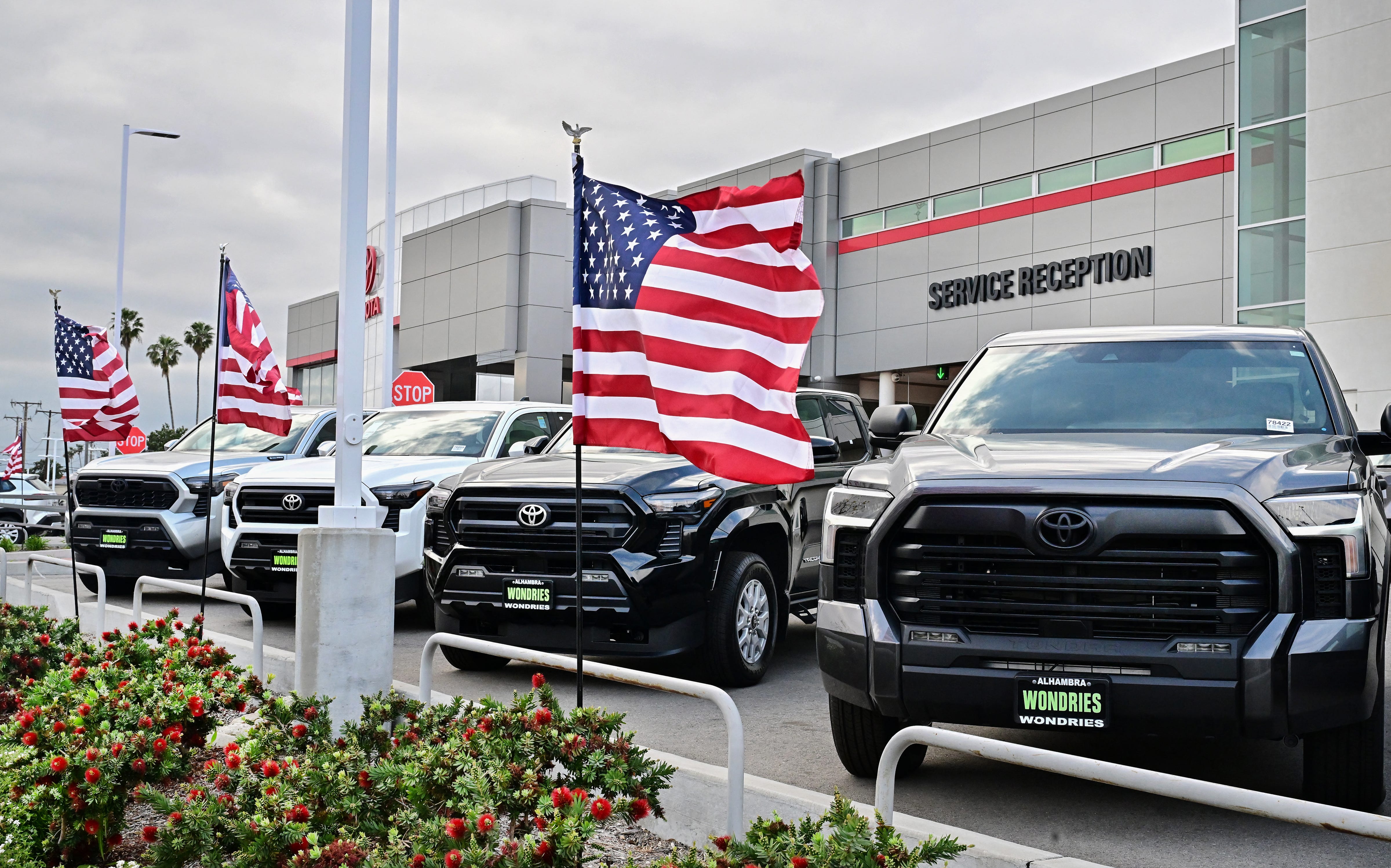 US flags fly outside a Toyota dealership in Alhambra, California, on March 27, 2025.