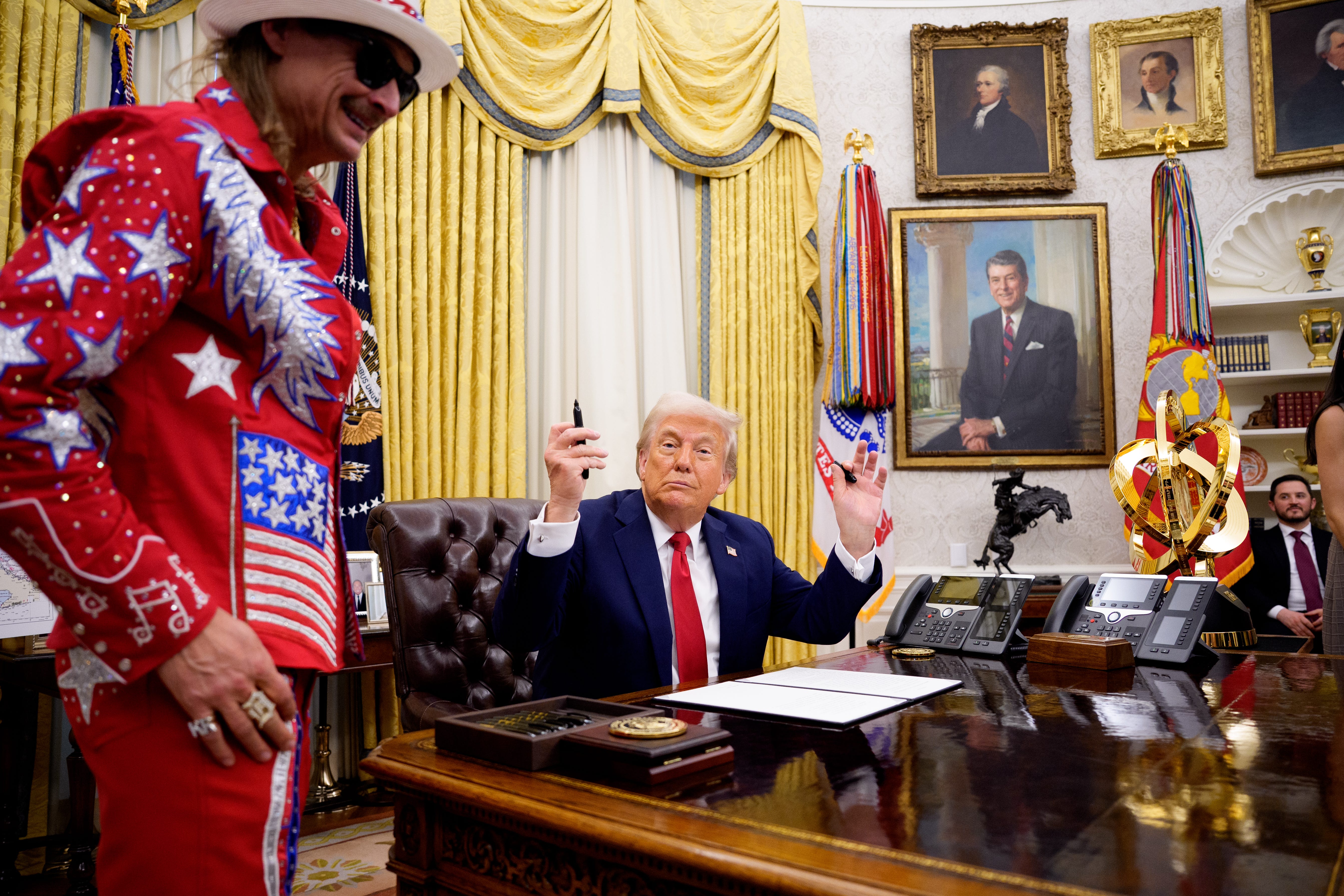 President Donald Trump, accompanied by entertainer Kid Rock, prepares to sign an executive order on March 31, 2025, against ticket scalping and reforming the live entertainment ticket industry.