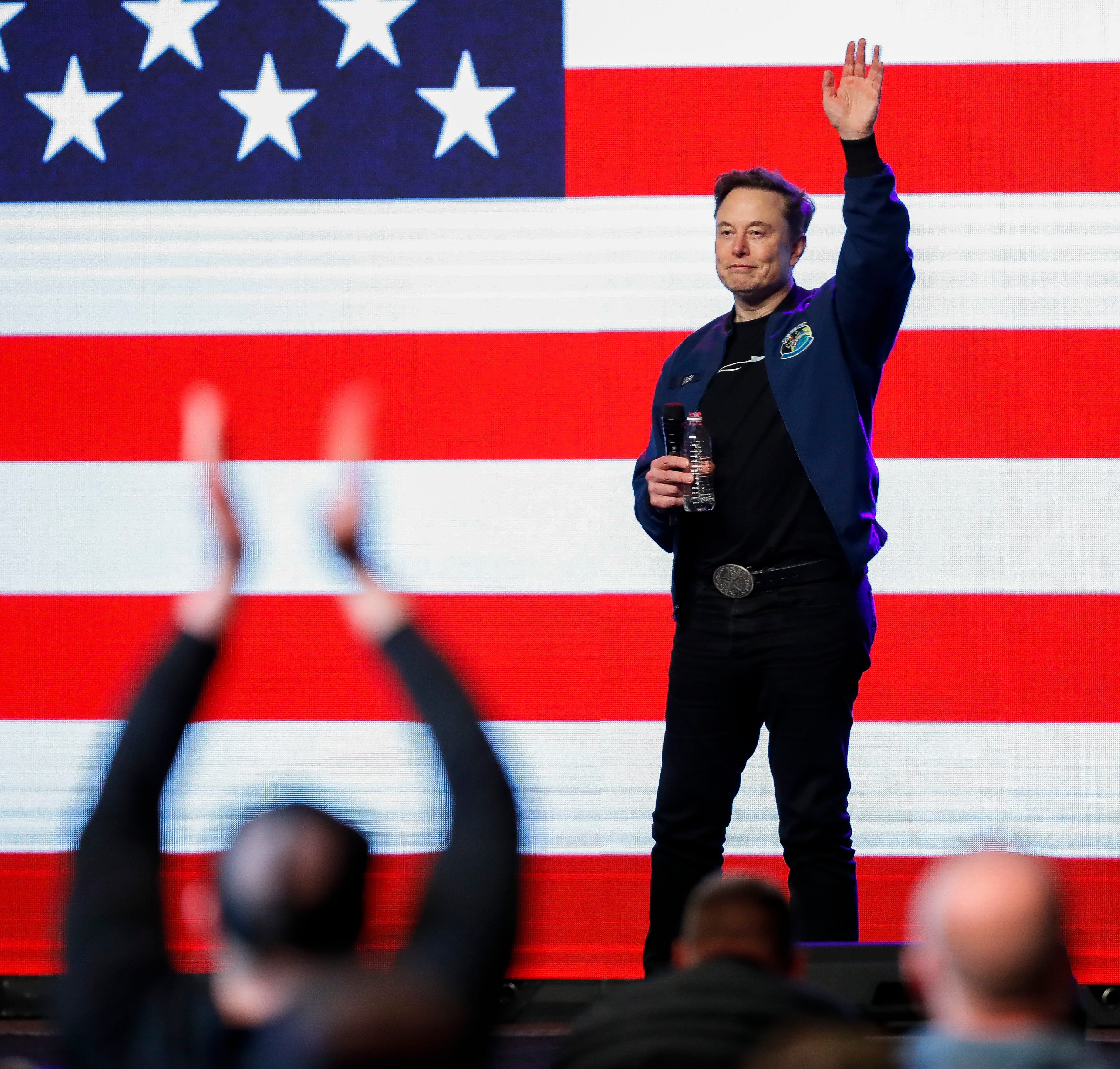 Elon Musk waves to the crowd at a town hall on March 30, 2025, in Green Bay, Wis.