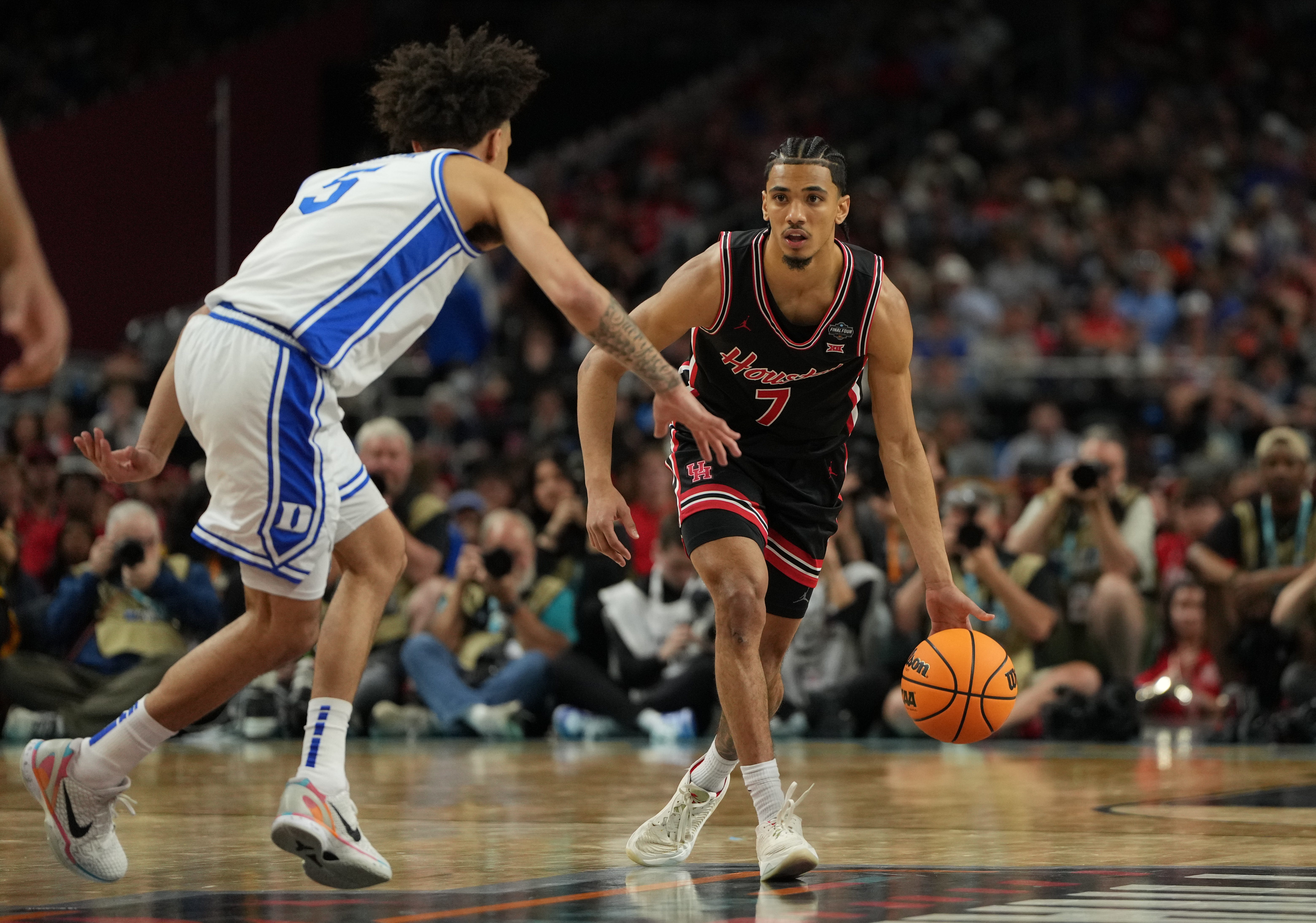 Houston guard Milos Uzan (7) dribbles the ball Duke guard Tyrese Proctor (5) during the national semifinals of the 2025 NCAA men's tournament at the Alamodome.