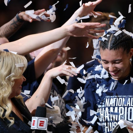 Apr 6, 2025; Tampa, FL, USA; Connecticut Huskies guard Azzi Fudd (35) gets confettied by her teammates while interviewed by ESPN reporter Holly Rowe after the national championship of the women's 2025 NCAA tournament against the South Carolina Gamecocks at Amalie Arena. Mandatory Credit: Nathan Ray Seebeck-Imagn Images