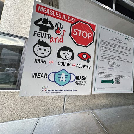 A measles alert sign hangs outside the entrance to the Cohen Children's Medical Center in New Hyde Park, New York on March 14, 2025.