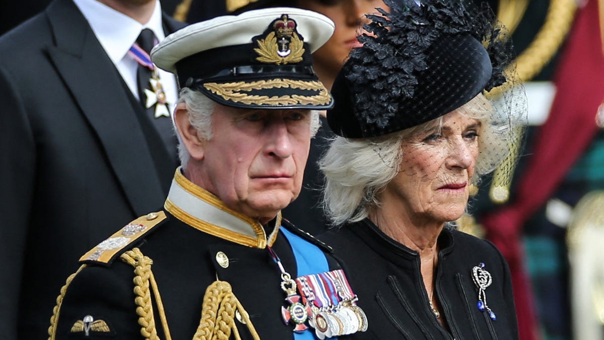 Britain's King Charles III and Britain's Camilla, Queen Consort look at members of the Bearer Party transferring the coffin of Queen Elizabeth II, draped in the Royal Standard, form the State Gun Carriage of the Royal Navy into the State Hearse at Wellington Arch in London on Sept. 19, 2022, after the State Funeral Service of Britain's Queen Elizabeth II.