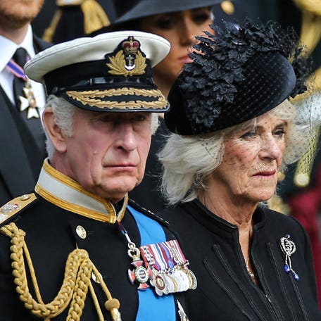 Britain's King Charles III and Britain's Camilla, Queen Consort look at members of the Bearer Party transferring the coffin of Queen Elizabeth II, draped in the Royal Standard, form the State Gun Carriage of the Royal Navy into the State Hearse at Wellington Arch in London on Sept. 19, 2022, after the State Funeral Service of Britain's Queen Elizabeth II.