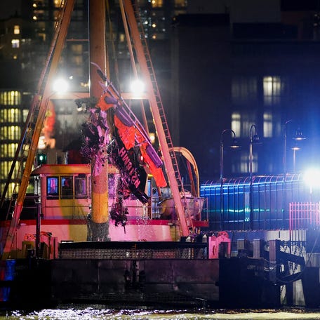 Emergency personnel work at the scene of a helicopter crash on the Hudson River near lower Manhattan in New York, as seen from Newport, New Jersey.