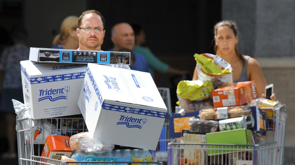 Shoppers make their way out a Costco in Jacksonville, Florida, on Tuesday, September 5, 2017, as they stocked up on supplies ahead of Hurricane Irma.
