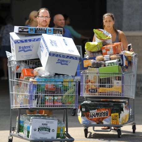 Shoppers make their way out a Costco in Jacksonville, Florida, on Tuesday, September 5, 2017, as they stocked up on supplies ahead of Hurricane Irma.