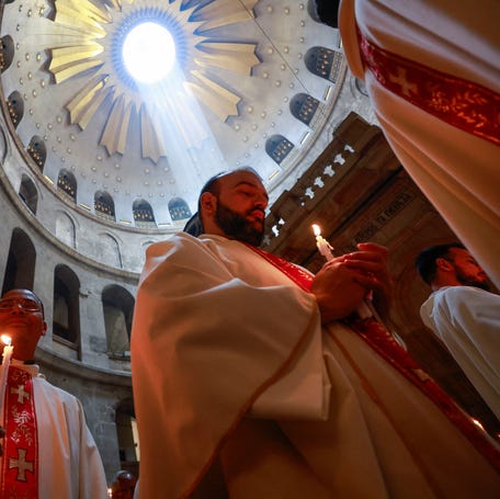 Members of the clergy take part in a procession during Holy Week in the Church of the Holy Sepulchre in Jerusalem's Old City on April 17, 2025.