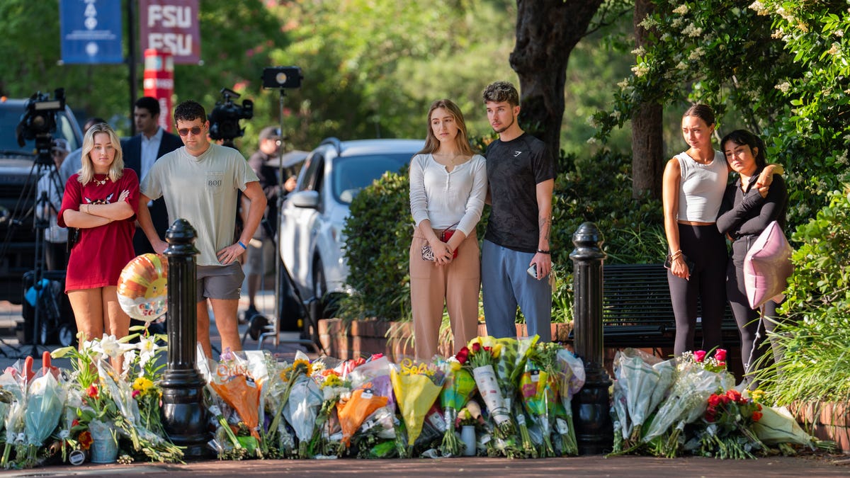 Florida State University students and other visit memorials set up near the student union the morning after a shooter killed two and injured six, Friday, April 18, 2025.