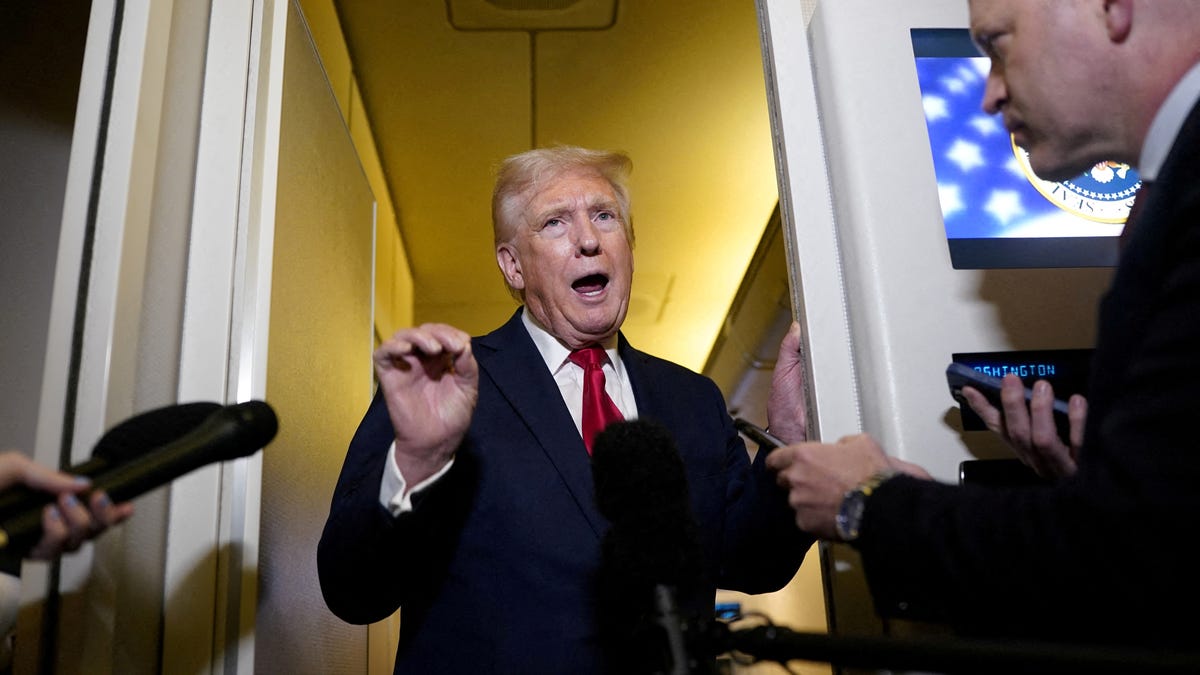 FILE PHOTO: U.S. President Donald Trump speaks to members of the media onboard Air Force One, on a flight to Joint Base Andrews in Maryland, U.S. April 13, 2025. REUTERS/Nathan Howard/File Photo