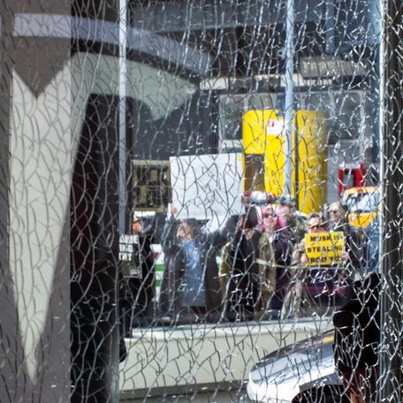 A broken window is seen while people protest outside of a Tesla store during a National Day of Tesla Protest in New York City, U.S., March 1, 2025. REUTERS/Eduardo Munoz