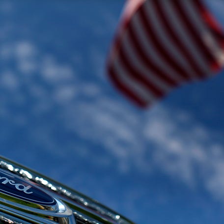 A Ford truck sits for sale under an American flag at a dealership lot in Encinitas, California, July 25, 2011.