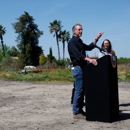 California Governor Gavin Newsom speaks as almond farmer Christine Gemperle looks on during a news conference at Gemperle Orchard on April 16, 2025 in Ceres, California.