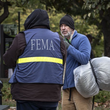 Ether Ashe, who says that he is currently homeless, speaks with a FEMA representative outside the Buncombe County Courthouse in Asheville, on N.C. Oct. 16, 2024.