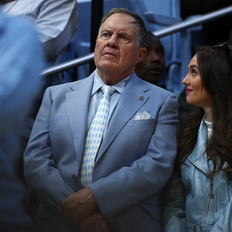 UNC football coach Bill Belichick and his girlfriend Jordon Hudson look on during the first half of a basketball game in Chapel Hill.