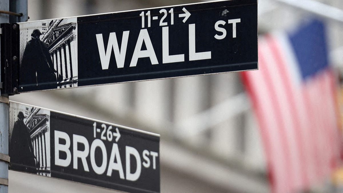 FILE PHOTO: A Wall Street sign hangs in front of a U.S. Flag outside the New York Stock Exchange (NYSE) before the Federal Reserve announcement in New York City, U.S., September 18, 2024. REUTERS/Andrew Kelly/File Photo