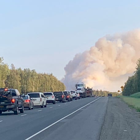 Smoke billows in the distance from the McKinley Fire as traffic backed up near Mile 95 of the George Parks Highway near the Montana Creek Campground in Willow, Alaska in June 2024. The fire temporarily stopped traffic in both directions on the Alaska Railway.