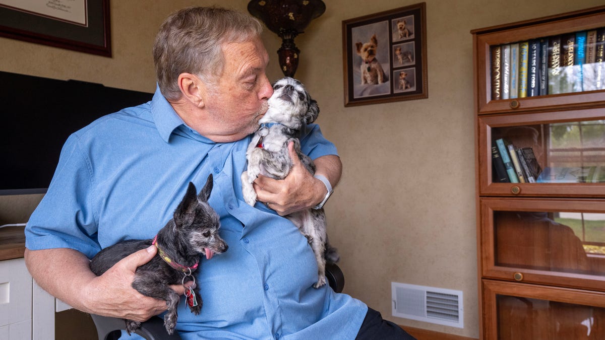 Dave Cook had little support while providing care for his wife, Pat, at home while she was dying. He retired to take care of her in 2018. When she developed lymphedema she became "virtually immobile." She had developed open sores and he had to administer pain medication despite having hospice care. Her pain was so great that she asked him to kill her, more than once. She died in December 2024. He is shown with his dogs Bucky, left, and Mickey on Tuesday, April 29, 2025 in Racine, Wisconsin.