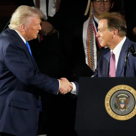 President Donald Trump shakes hands with former Alabama football coach Nick Saban before speaking to Alabama graduates in Tuscaloosa on Thursday, May 1, 2025.
