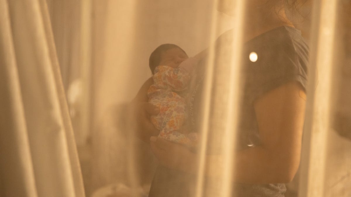 Erika Mateo, a 24-year-old Guatemalan woman who gave birth in a Tucson hospital after being apprehended by Border Patrol in the southwestern Arizona desert, holds her newborn girl in the comfort of her hotel room in Phoenix on May 3, 2025.