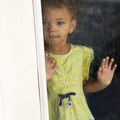 A student enrolled in an Early Head Start program waits to go out to the Farmington Children's Center playground in Maine on April 29.