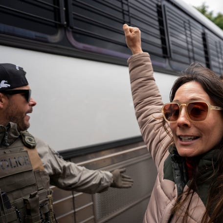 Ashley Warrington walks with other protesters alongside a bus being escorted by Immigration Customs and Enforcement officers (ICE) and Homeland Security officers at the Department of Homeland Security field office in Nashville, Tenn., on May 4, 2025.