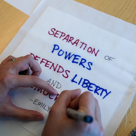 Political messages written on white fabric that will be sewn into quilts to be displayed in Congress for the Peace by Piece initiative, in this April 28, 2025, photo taken in Highlands Ranch, Colorado.