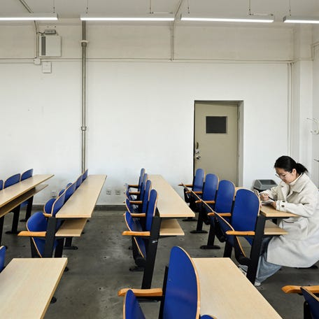 This photo taken on March 13, 2025 shows student Liu Yuxuan reading a book at a university classroom in Beijing.