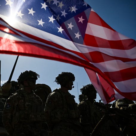 Army soldiers stand in formation next to a U.S. flag and a U.S. Army armored vehicle as they take part in the NATO "Noble Blueprint 23" joint military exercise at the Novo Selo military ground, northwestern Bulgaria, on September 26, 2023.