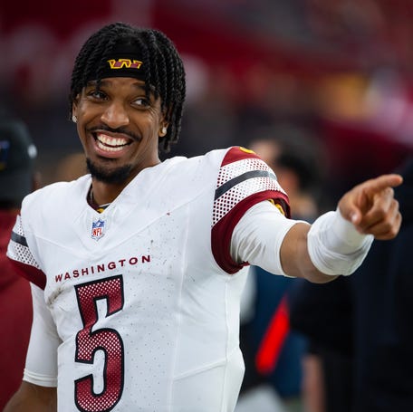 Washington Commanders quarterback Jayden Daniels (5) celebrates against the Arizona Cardinals at State Farm Stadium.