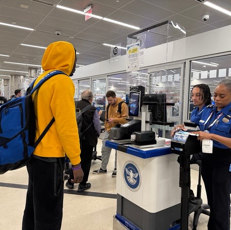 TSA agents check passenger identification at Hartsfield-Jackson Atlanta International Airport in Atlanta as REAL ID requirements take effect on May 7, 2025. Travelers flying within the United States will now need a REAL ID-compliant driver's license or an approved alternative – like a passport – to pass through airport security.