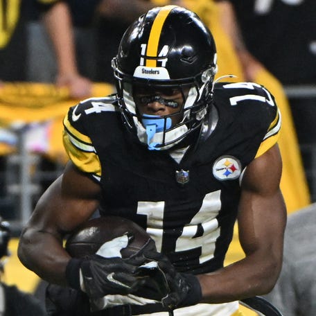 Oct 6, 2024; Pittsburgh, Pennsylvania, USA; Pittsburgh Steelers wide receiver George Pickens (14) makes a catch in front of Dallas Cowboys safety Donovan Wilson (6) during the fourth quarter at Acrisure Stadium. Mandatory Credit: Barry Reeger-Imagn Images
