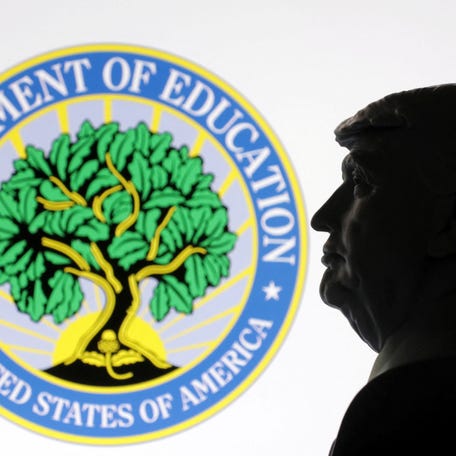 A 3D-printed miniature model of President Donald Trump with the U.S. Department of Education logo in the background is seen in this illustration taken on April 23, 2025.