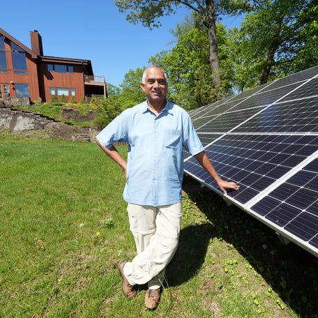 Chandu Visweswariah, who lives in an all-electric, zero-carbon house, stands next to the solar panels in his backyard May 7, 2025 in Croton-on-Hudson. Visweswariah outfitted his home with solar panels and electrical appliances in 2008 out of concern for the damaging effect that natural gas has on the environment. He's involved in the non-profit CURE100 which advises others on how to make the transition to electric.