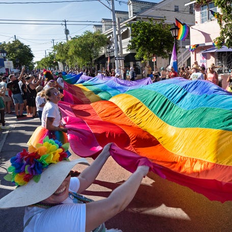 Marchers in the Key West Pride parade carry a 100-foot-long section of an iconic 1.25-mile-long rainbow flag Sunday, June 11, 2023, up Duval Street in Key West, Fla. The parade commemorated the 20th anniversary of the flag's 2003 unfurling when it blanketed the entire street from the Gulf of Mexico to the Atlantic Ocean. Called the 