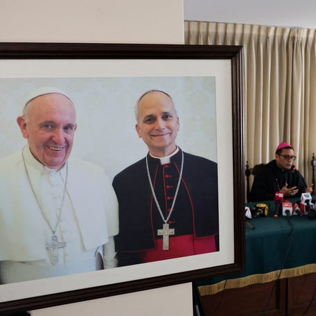 A photograph of the late Pope Francis and Pope Leo XIV prior to his election is displayed as Bishop Edinson Edgardo Farfan Cordova speaks during a press conference in Chiclayo, Peru, following Pope Leo's election, on May 9, 2025. REUTERS/Sebastian Castaneda