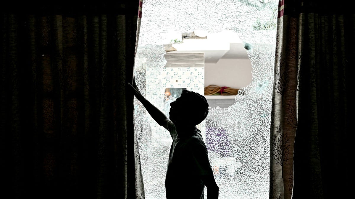 A man shows the shattered window of a house after cross-border shelling in Arnia town near the border area in India's Jammu region on May 10, 2025, amid a surge in border tensions between India and Pakistan. Pakistan launched counterattacks against India on May 10, after three of its air bases were struck overnight, and as the conflict between the nuclear-armed neighbours spiralled towards a full-blown war that sparked calls against "miscalculation". (Photo by Money SHARMA / AFP) (Photo   by MONEY SHARMA/AFP via Getty Images)