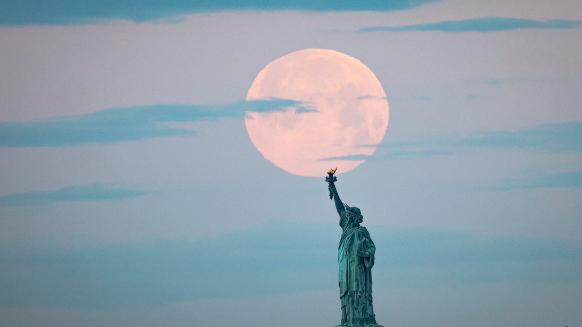 May's full Moon, known as the Full Flower Moon, sets behind the Statue of Liberty on May 7, 2020 in New York City