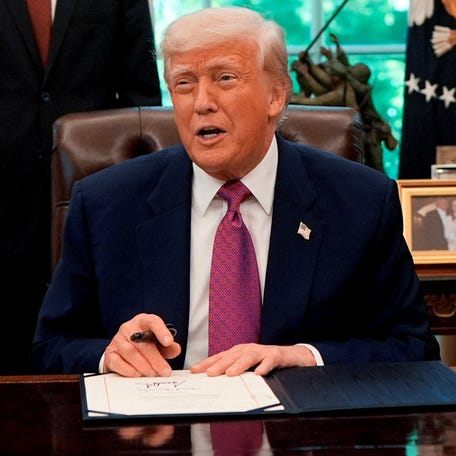 President Donald Trump is pictured signing a joint resolution at the White House.