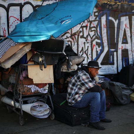 A man sits on a street in Skid Row, Los Angeles, California on Dec. 9, 2024.